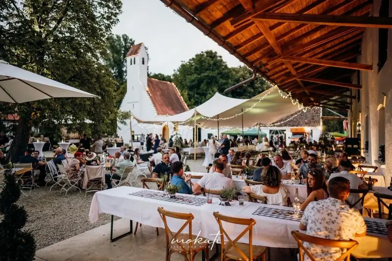 Evening event under the wooden roof at Hofgut Sickertshofen, with string lights