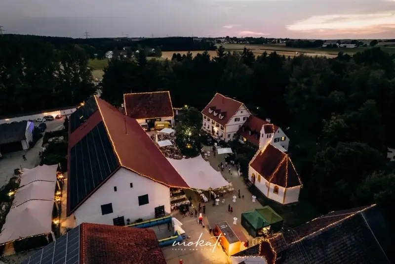Aerial view of the illuminated Hofgut Sickertshofen at dusk